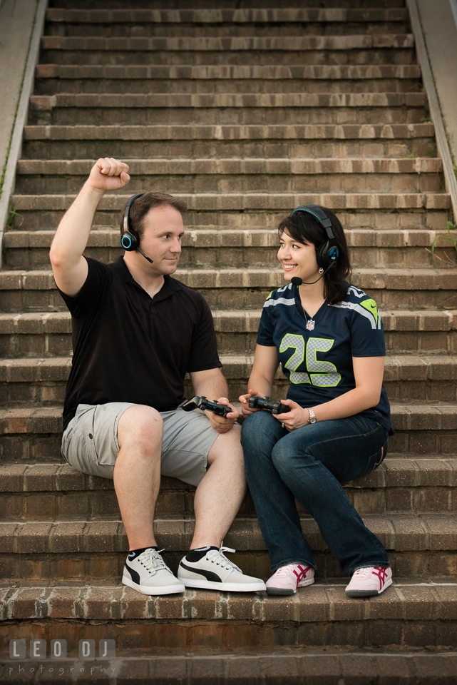 Engaged girl with her fiancé sitting on the stairs using video game controller and headset. Quiet Waters Park Annapolis Maryland pre-wedding engagement photo session, by wedding photographers of Leo Dj Photography. http://leodjphoto.com