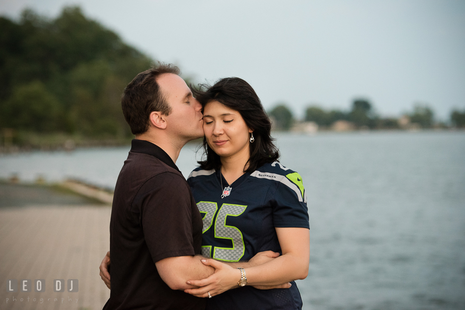 Engaged man holding and kissing his fiancee. Quiet Waters Park Annapolis Maryland pre-wedding engagement photo session, by wedding photographers of Leo Dj Photography. http://leodjphoto.com