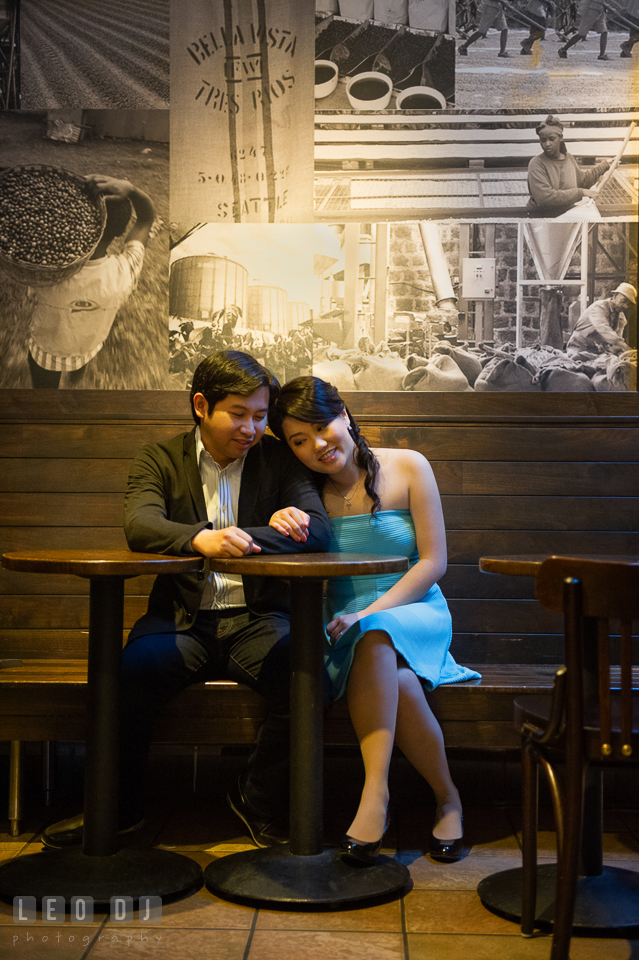 Engaged guy cuddling with his fiancee in a coffee shop. Annapolis Eastern Shore Maryland pre-wedding engagement photo session at downtown, by wedding photographers of Leo Dj Photography. http://leodjphoto.com