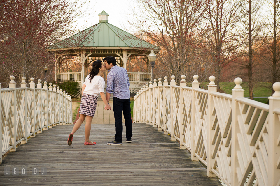 Engaged couple kissing on the bridge. Quiet Waters Park Annapolis Maryland pre-wedding engagement photo session, by wedding photographers of Leo Dj Photography. http://leodjphoto.com