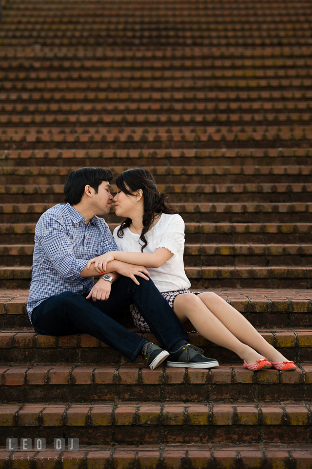 Engaged couple by the stairs snuggling and almost kissing. Quiet Waters Park Annapolis Maryland pre-wedding engagement photo session, by wedding photographers of Leo Dj Photography. http://leodjphoto.com