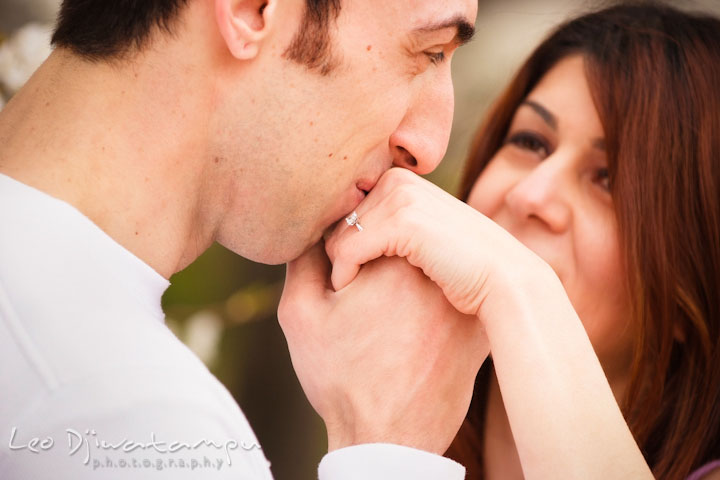 Engaged guy kissed his fiancée hand with an engagement ring. Washington DC Tidal Basin Cherry Blossom Pre-Wedding Engagement Photo Session by Wedding Photographer Leo Dj Photography