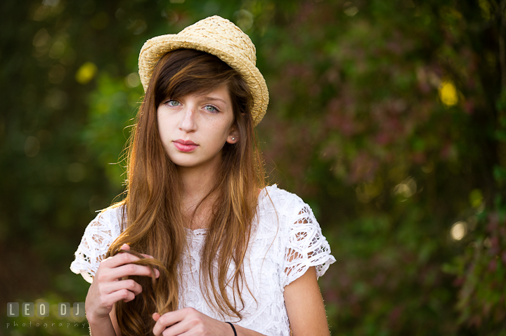 Pretty girl with hat playing with her long hair. Easton, Centreville, Maryland, High School senior portrait session by photographer Leo Dj Photography. http://leodjphoto.com