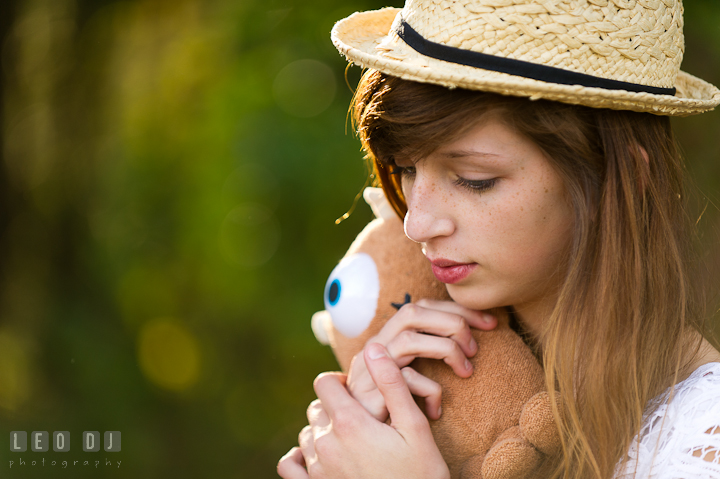 Girl cuddling little Mikey doll from Monster's Inc movie. Easton, Centreville, Maryland, High School senior portrait session by photographer Leo Dj Photography. http://leodjphoto.com