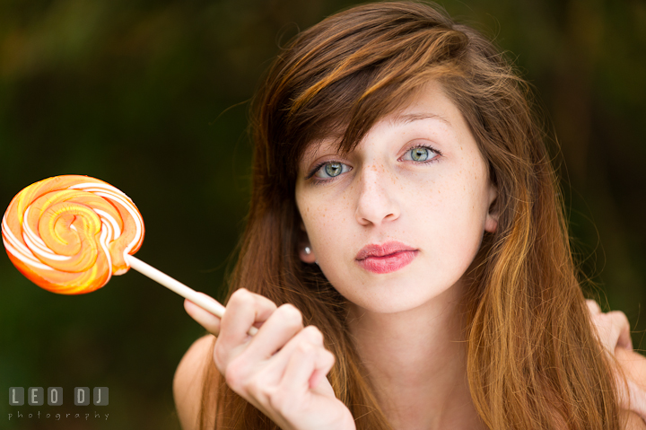 Pretty girl with gorgeous eyes holding big yellow lollipop. Easton, Centreville, Maryland, High School senior portrait session by photographer Leo Dj Photography. http://leodjphoto.com