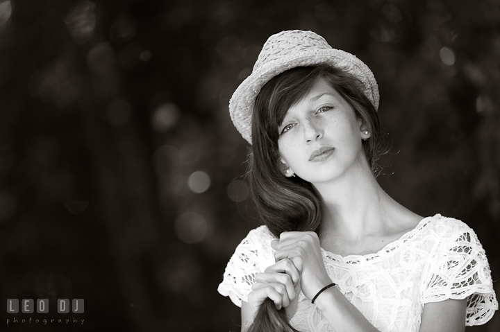 Girl in white dress and hat playing with heir hair. Eastern Shore, Maryland, High School senior portrait session by photographer Leo Dj Photography. http://leodjphoto.com