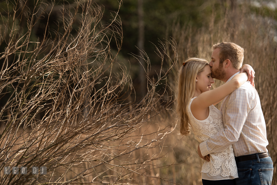 Engaged girl kissed on the forehead by her fiance. Quiet Waters Park Annapolis Maryland pre-wedding engagement photo session, by wedding photographers of Leo Dj Photography. http://leodjphoto.com