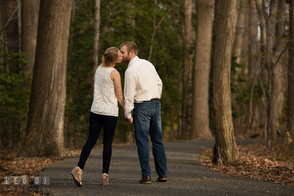 Engaged couple in the woods holding hands and kissing. Quiet Waters Park Annapolis Maryland pre-wedding engagement photo session, by wedding photographers of Leo Dj Photography. http://leodjphoto.com