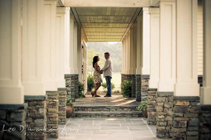 engaged couple holding hands at the end of columns. Kent Island, Eastern Shore, Maryland Engagement Pre-wedding photography session