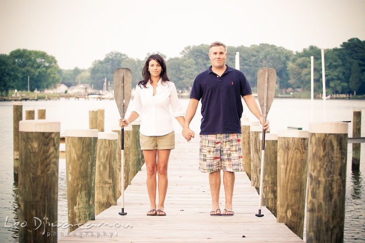 engaged guy and girl holding boat paddle on pier. Kent Island, Eastern Shore, Maryland Engagement Pre-wedding photography session