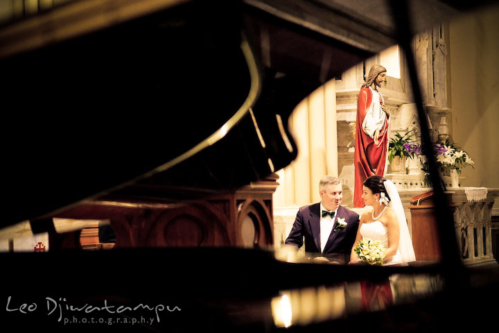 Bride and groom sitting, looking at each other, and smiling during the ceremony. Annapolis Wedding Photographer, Wedding at St Mary's Catholic Church Annapolis Maryland.