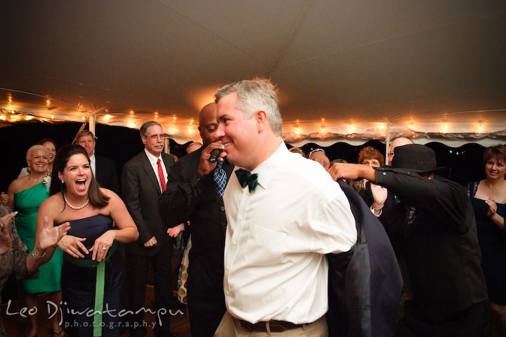 Groom takes off his jacket, helped by the wedding singers. Annapolis Kent Island Maryland Wedding Photography with live dance band at reception