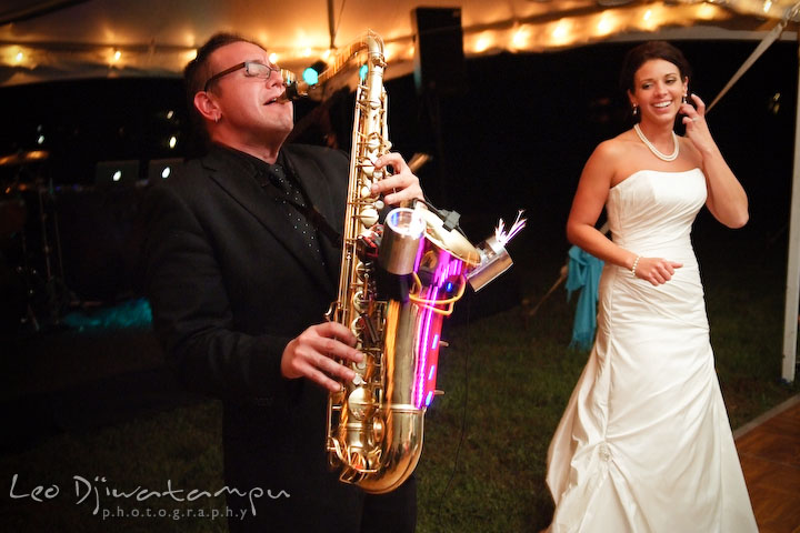 Saxohponist showing lights and sparkle display to bride. Annapolis Kent Island Maryland Wedding Photography with live dance band at reception