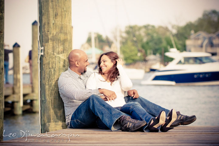 Engaged couple sitting on the pier Annapolis downtown harbor. Annapolis Maryland USNA Pre-Wedding Engagement Photo Session by wedding photographer Leo Dj Photography