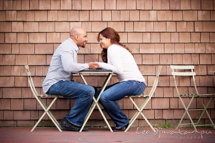 Engaged couple sitting at restaurant table outside. Annapolis Maryland USNA Pre-Wedding Engagement Photo Session by wedding photographer Leo Dj Photography