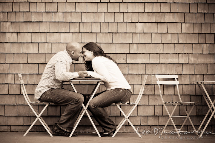 A girl and her fiancé almost kissed at a restaurant table outside. Annapolis Maryland USNA Pre-Wedding Engagement Photo Session by wedding photographer Leo Dj Photography