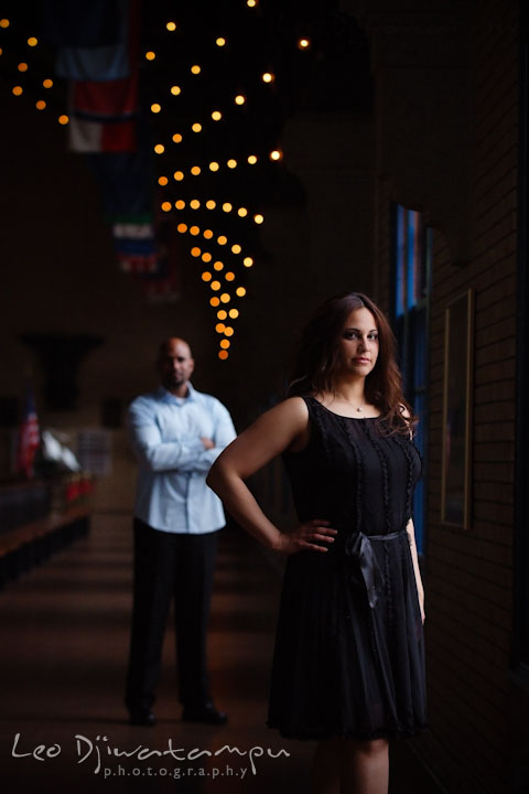 An engaged girl posing inside a USNA building, her fiancé is behind her. Annapolis Maryland USNA Pre-Wedding Engagement Photo Session by wedding photographer Leo Dj Photography