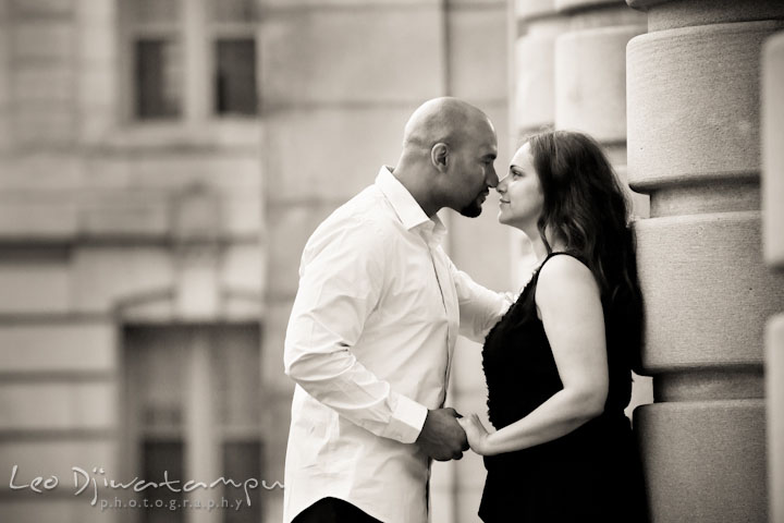 Engaged guy and girl almost kissed by the USNA building columns. Annapolis Maryland USNA Pre-Wedding Engagement Photo Session by wedding photographer Leo Dj Photography