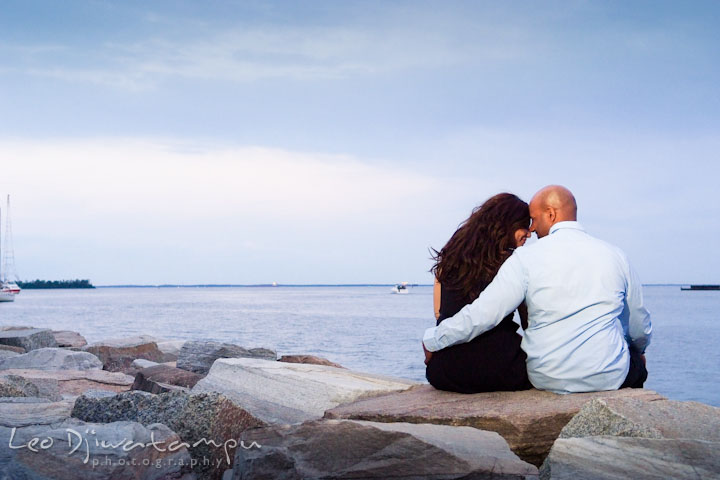 Engaged guy and girl cuddling and enjoying the water view. Annapolis Maryland USNA Pre-Wedding Engagement Photo Session by wedding photographer Leo Dj Photography