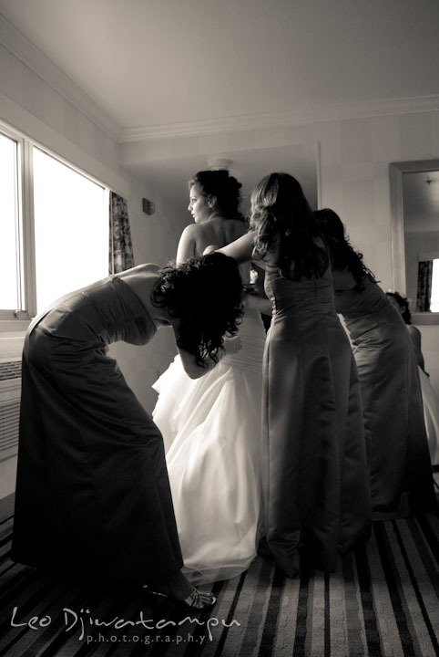 Maid of honor and bridesmaids help bride buttonning up dress. The Grand Marquis, Old Bridge, New Jersey wedding photos by wedding photographers of Leo Dj Photography. 