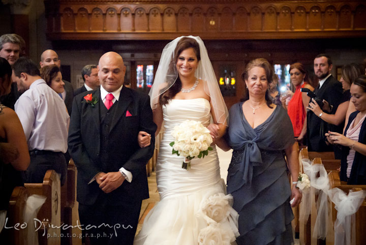 Bride going down the isle escorted by uncle and mother. The Grand Marquis, Old Bridge, New Jersey wedding photos by wedding photographers of Leo Dj Photography. 