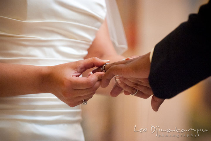 Bride putting on ring on groom's finger. The Grand Marquis, Old Bridge, New Jersey wedding photos by wedding photographers of Leo Dj Photography. 