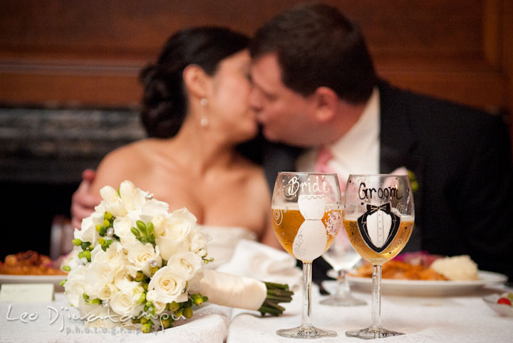 Bride and groom kissing at the sweetheart table. Overhills Mansion Catonsville Baltimore MD wedding photos by photographers of Leo Dj Photography