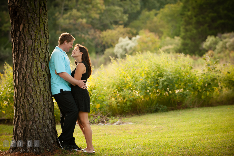 Engaged couple cuddling by a tree. Eastern Shore Maryland pre-wedding engagement photo session at Easton MD, by wedding photographers of Leo Dj Photography. http://leodjphoto.com