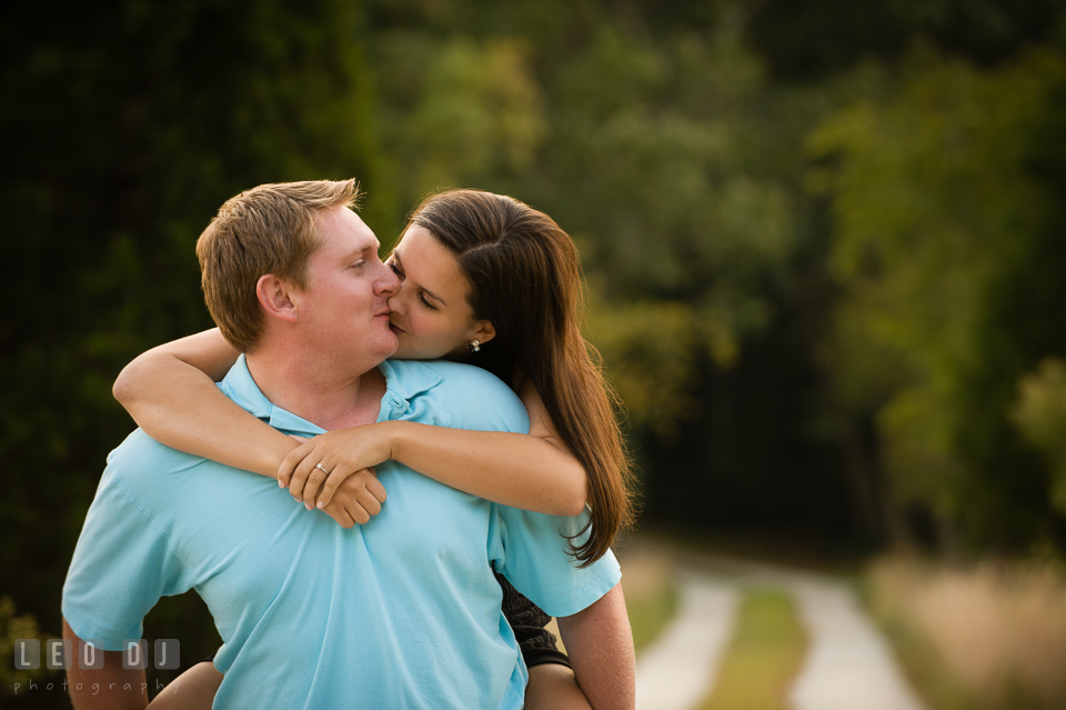 Engaged man carrying his fiancée on his back and kissing. Eastern Shore Maryland pre-wedding engagement photo session at Easton MD, by wedding photographers of Leo Dj Photography. http://leodjphoto.com