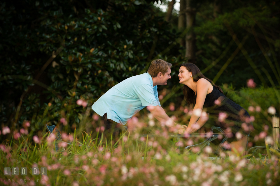 Engaged couple in a flower garden holding hands. Eastern Shore Maryland pre-wedding engagement photo session at Easton MD, by wedding photographers of Leo Dj Photography. http://leodjphoto.com