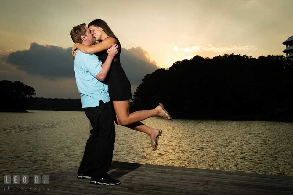 Engaged man lifted up his fiancee on the boat dock during sunset. Eastern Shore Maryland pre-wedding engagement photo session at Easton MD, by wedding photographers of Leo Dj Photography. http://leodjphoto.com