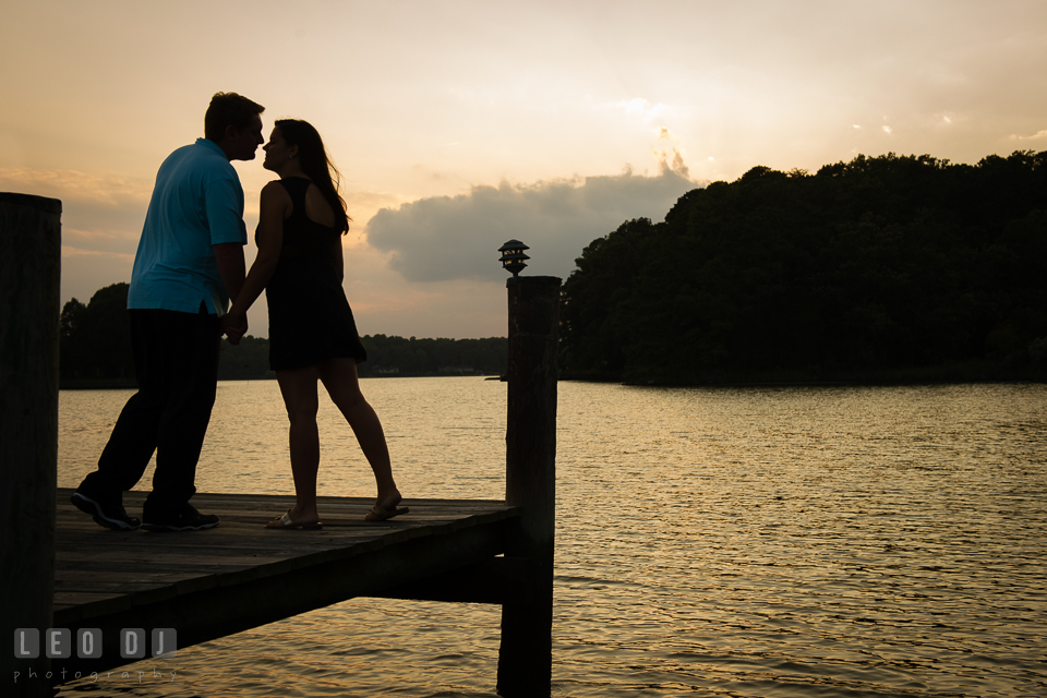 Engaged couple on the boat dock holding hands and almost kissed during sunset. Eastern Shore Maryland pre-wedding engagement photo session at Easton MD, by wedding photographers of Leo Dj Photography. http://leodjphoto.com