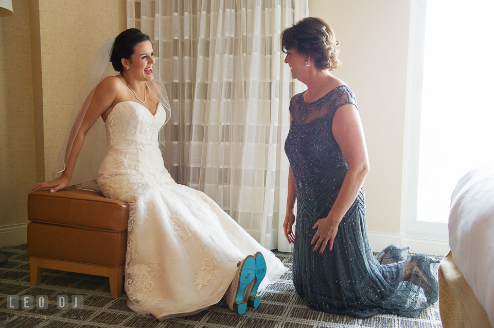 Bride and Mother of the Bride smiling after putting on Bride's shoes. Hyatt Regency Chesapeake Bay wedding at Cambridge Maryland, by wedding photographers of Leo Dj Photography. http://leodjphoto.com