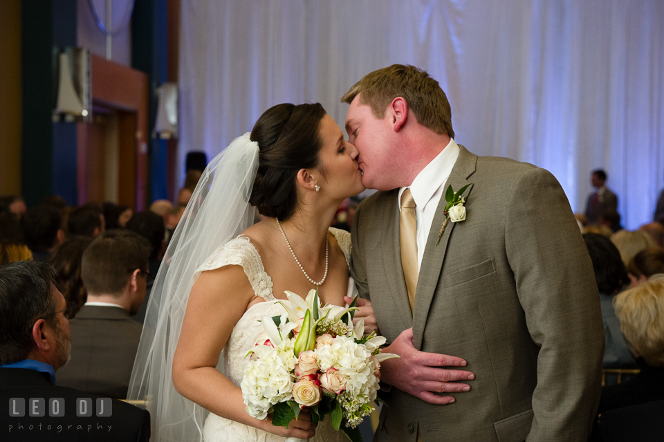 Bride and Groom kissing after recessional. Hyatt Regency Chesapeake Bay wedding at Cambridge Maryland, by wedding photographers of Leo Dj Photography. http://leodjphoto.com