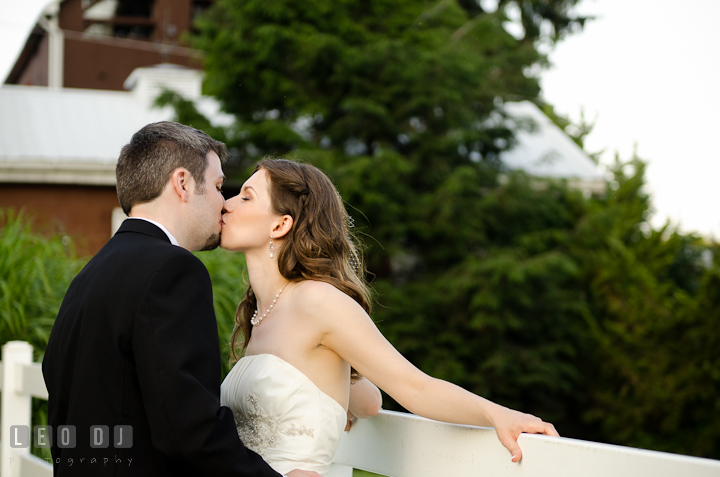 Bride and Groom kissing by a fence. Ostertag Vistas wedding reception photos at Myersville, Maryland by photographers of Leo Dj Photography. http://leodjphoto.com