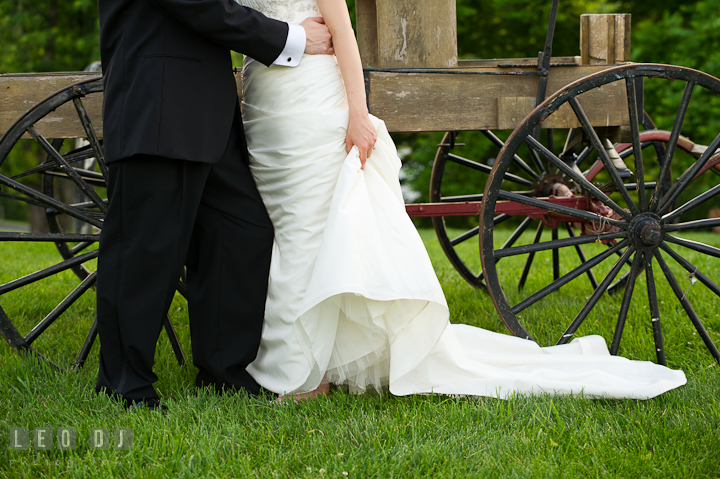 Bride and Groom's cuddling by an old wagon. Ostertag Vistas wedding reception photos at Myersville, Maryland by photographers of Leo Dj Photography. http://leodjphoto.com