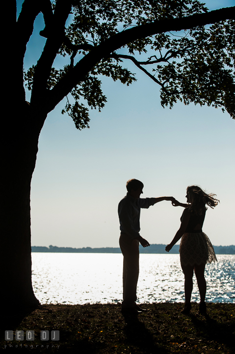Engaged guy twirling dancing fiancée. Oxford, Eastern Shore Maryland pre-wedding engagement photo session, by wedding photographers of Leo Dj Photography. http://leodjphoto.com