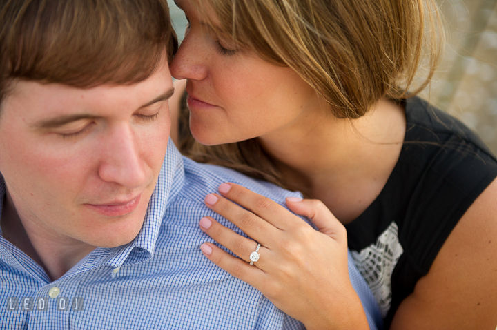 Engaged couple cuddling and showing engagement ring. Oxford, Eastern Shore Maryland pre-wedding engagement photo session, by wedding photographers of Leo Dj Photography. http://leodjphoto.com