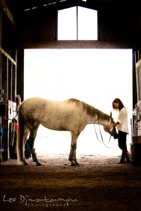 Girl holding her horse in a stable. Annapolis Kent Island Maryland High School Senior Portrait Photography with Horse Pet by photographer Leo Dj