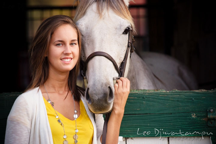 Girl posing with her horse looking at the camera. Annapolis Kent Island Maryland High School Senior Portrait Photography with Horse Pet by photographer Leo Dj