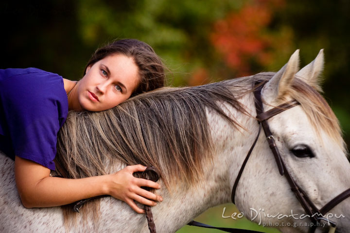 Girl owner laying on horse. Annapolis Kent Island Maryland High School Senior Portrait Photography with Horse Pet by photographer Leo Dj