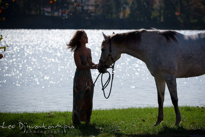 Sihouette of a girl talking to her mare by the water. Annapolis Kent Island Maryland High School Senior Portrait Photography with Horse Pet by photographer Leo Dj