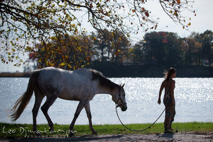 Girl owner walks her mare by the water. Annapolis Kent Island Maryland High School Senior Portrait Photography with Horse Pet by photographer Leo Dj