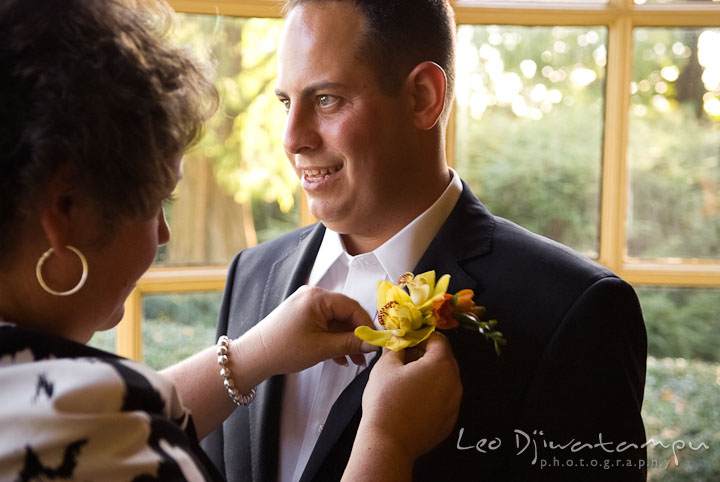 Wedding coordinator put on boutonniere on Groom. Mariott Aspen Wye River Conference Center Wedding photos at Queenstown Eastern Shore Maryland, by photographers of Leo Dj Photography.