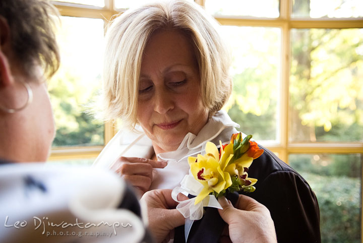 Wedding coordinator put on boutonniere on Mother of Groom. Mariott Aspen Wye River Conference Center Wedding photos at Queenstown Eastern Shore Maryland, by photographers of Leo Dj Photography.