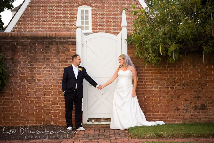 Bride and Groom holding hands, looking at each other by antique door. Mariott Aspen Wye River Conference Center Wedding photos at Queenstown Eastern Shore Maryland, by photographers of Leo Dj Photography.