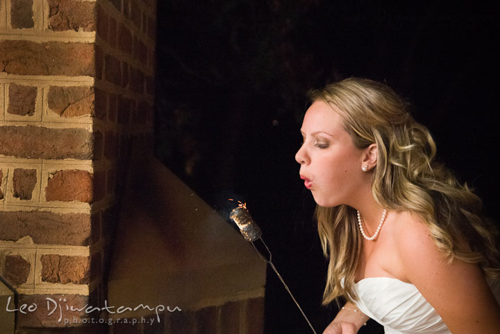 Bride blowing fire from marshmallows for s'mores. Mariott Aspen Wye River Conference Center Wedding photos at Queenstown Eastern Shore Maryland, by photographers of Leo Dj Photography.