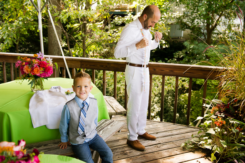 At home backyard wedding Groom putting on tie with nephew photo by Leo Dj Photography