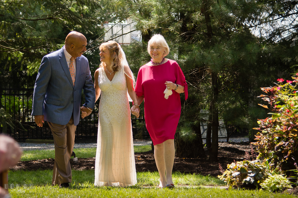 At home backyard Father and Mother escort Bride during ceremony processional photo by Leo Dj Photography