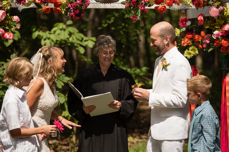 At home backyard wedding Bride and Groom laughing before put on ring at ceremony photo by Leo Dj Photography